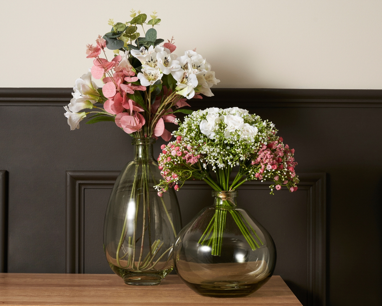 two large round vases with blooms in