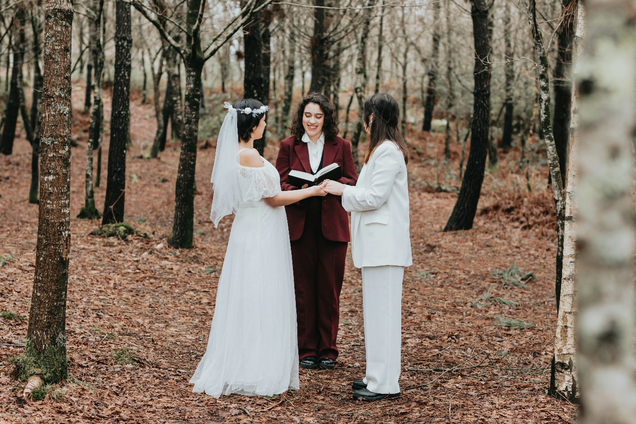 Celebrant with two brides in the woods