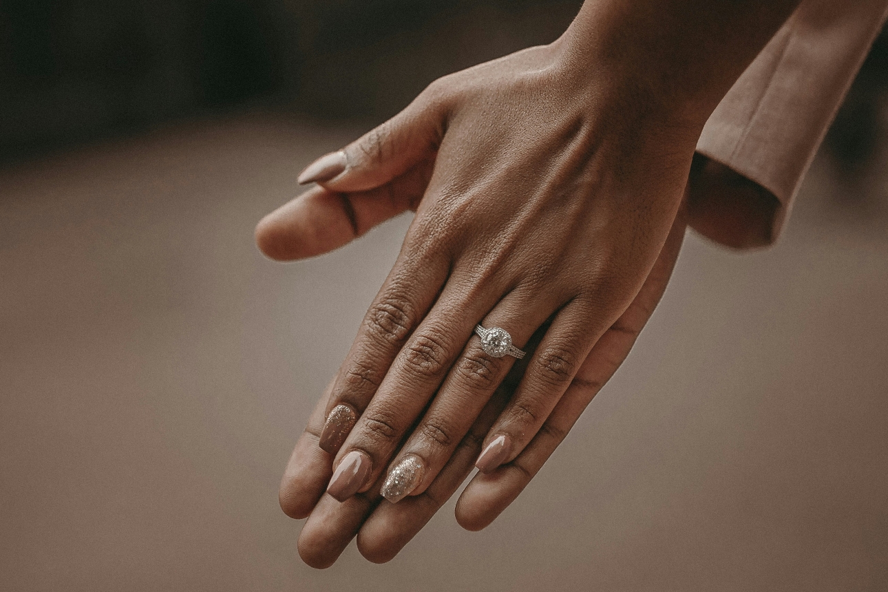 engagement ring on a hand with nails painted