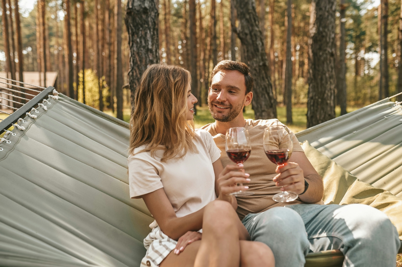 couple with wine in hammock in woods