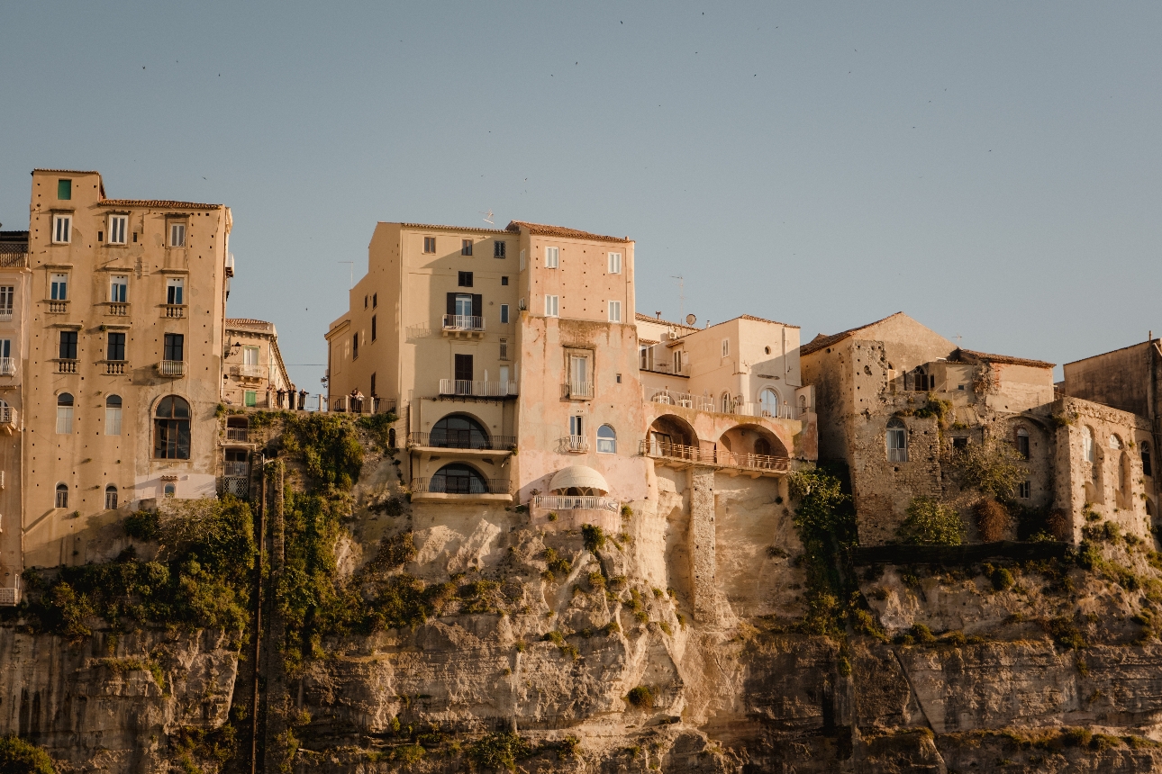 Buildings on the side of a cliff viewed from the sea