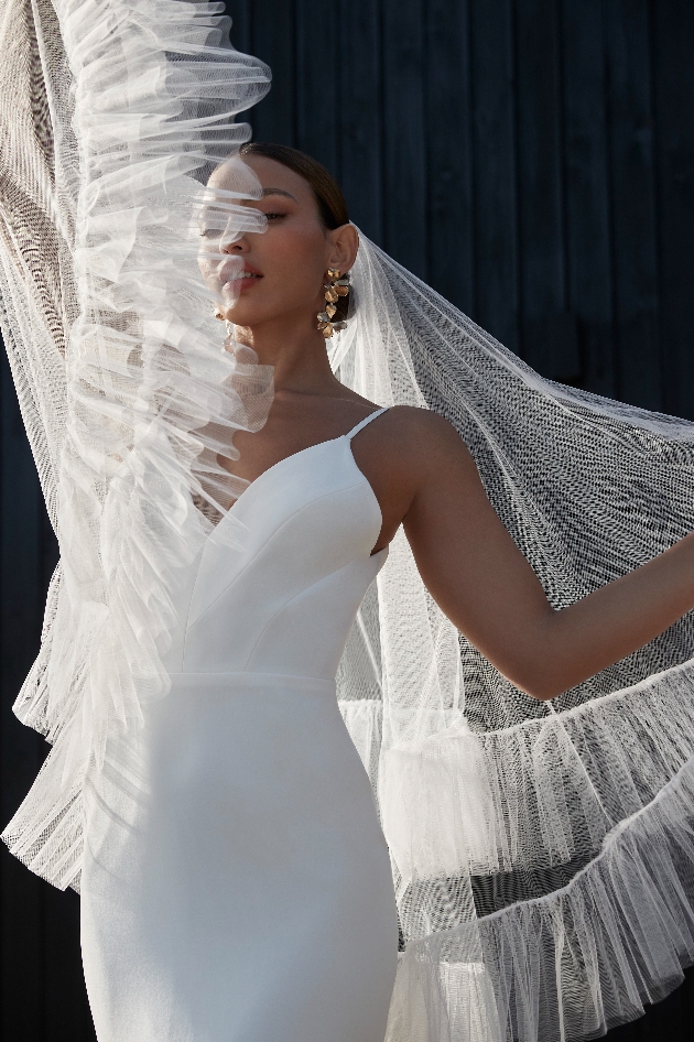 bride dress with net draping holding up in fashion style pose