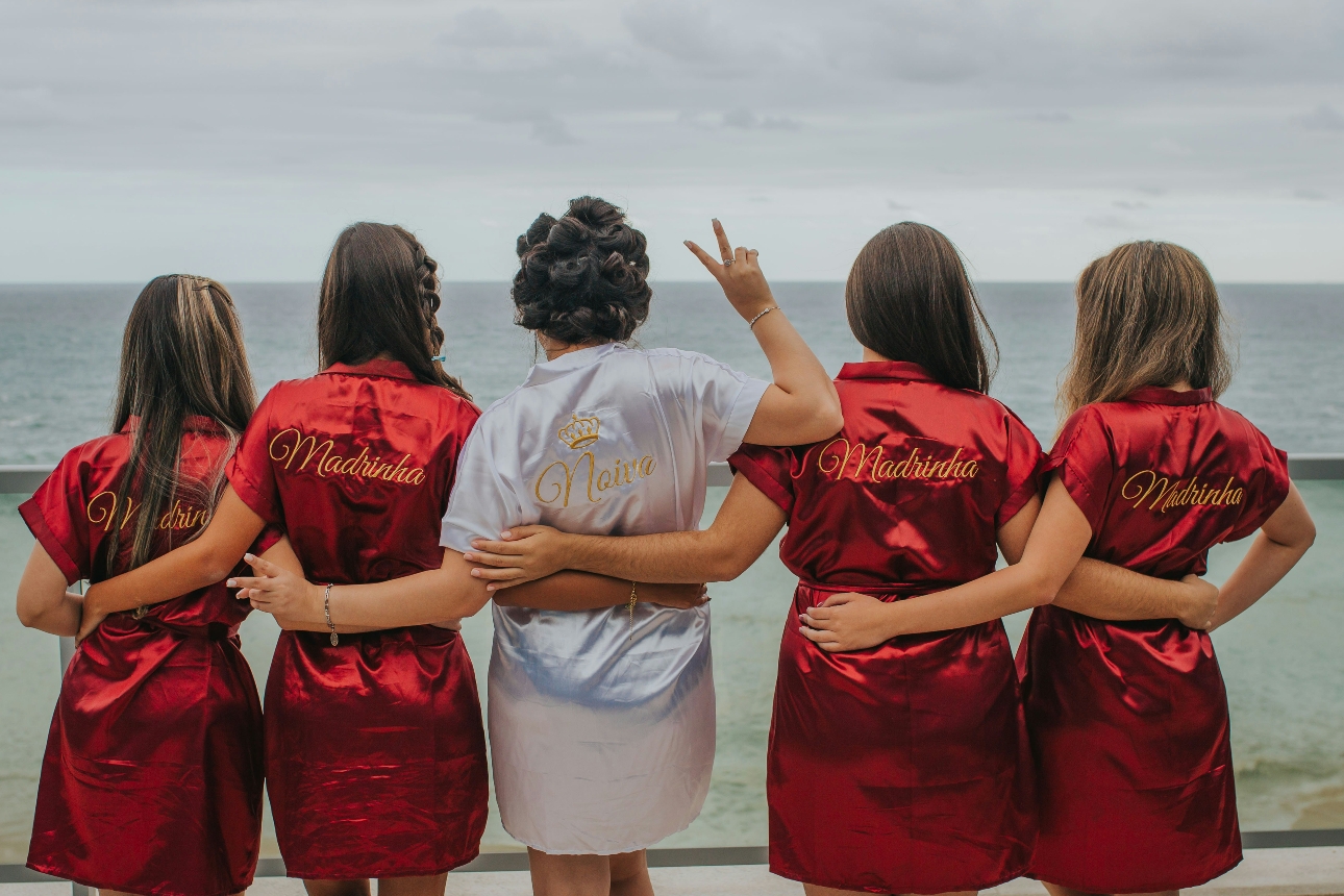 bridal party standing in line in front of sea