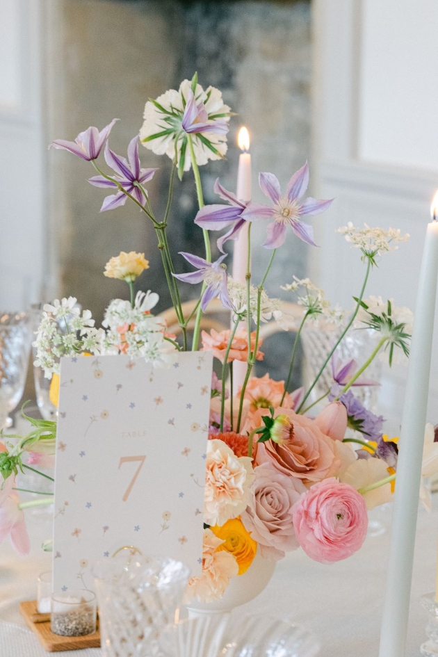 table number next to urn of table flowers in muted colours