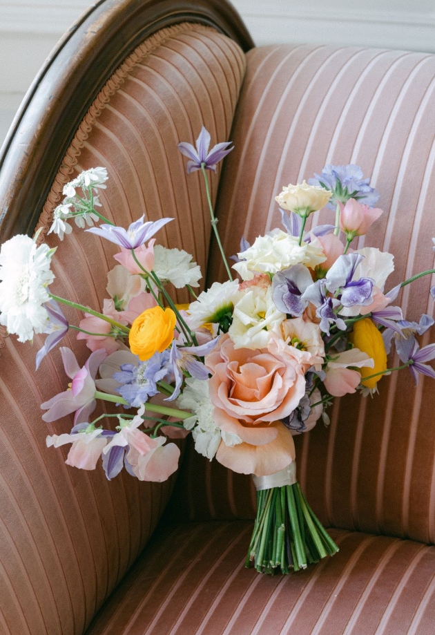 muted colour bouquet of flowers on striped chair 