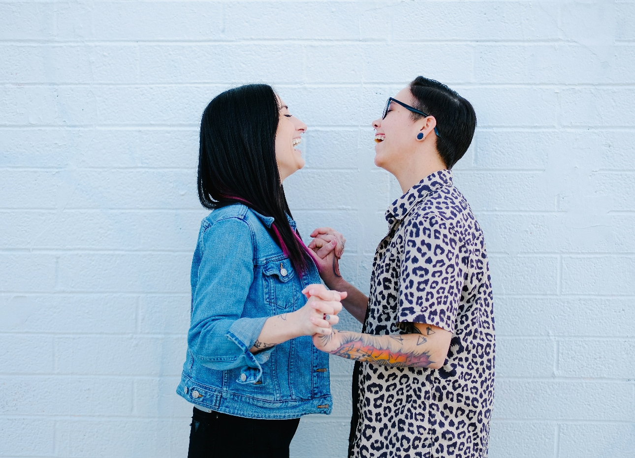 couple embracing in front of pink wall