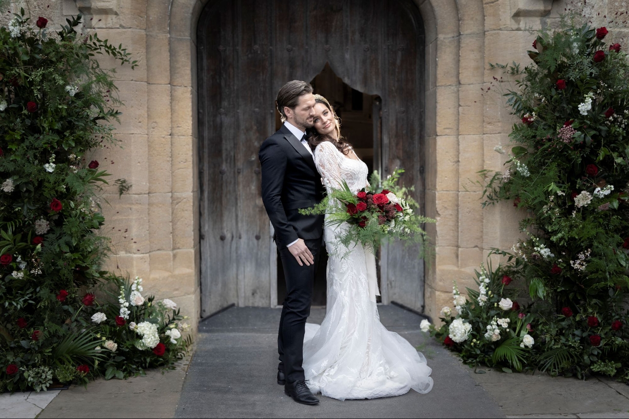 bride and groom in front of wooden doorway