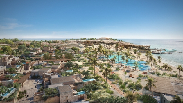 A sky view of a beach with buildings near it